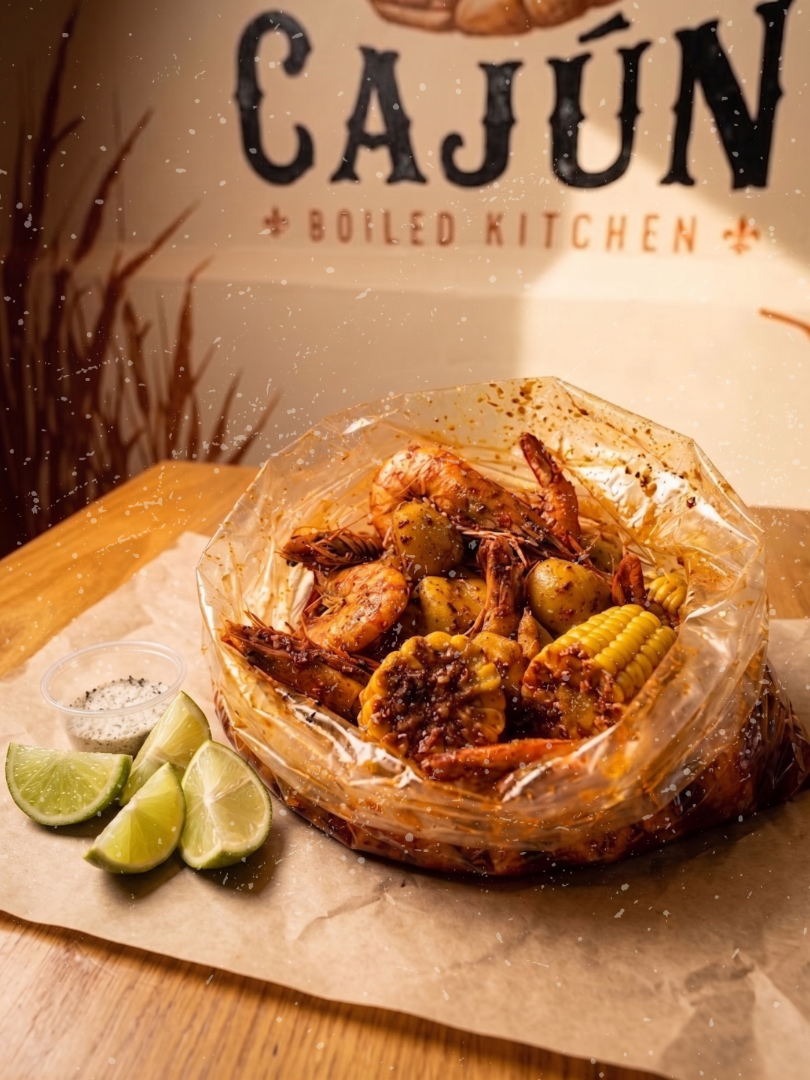 Camarones cajún en bolsa con papa, elote y limones